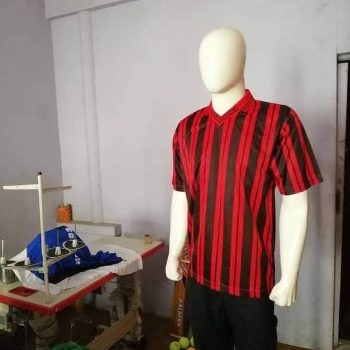 Sample garment on mannequin next to cutting table and sewing station