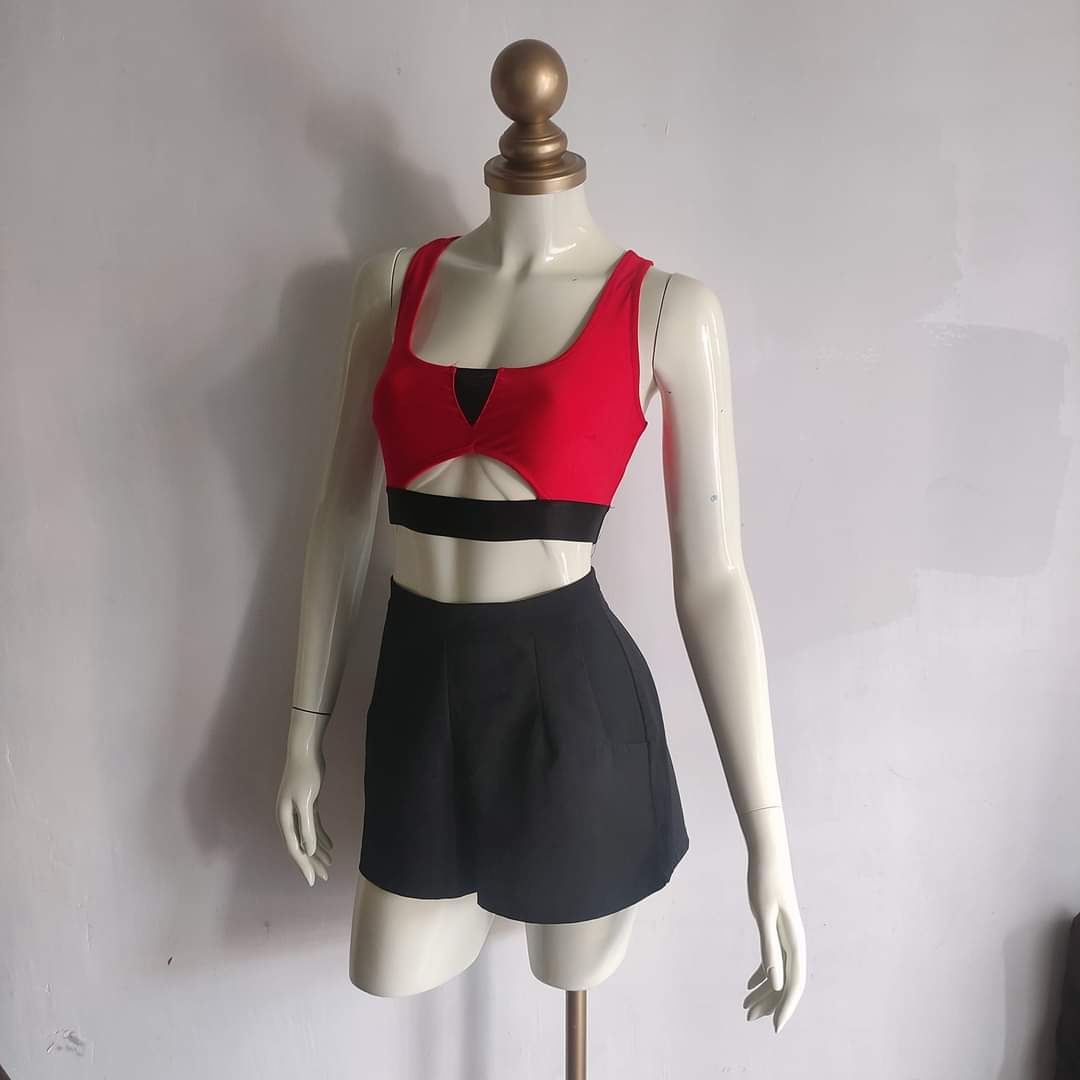 Red cropped top and black pleated shorts set on mannequin